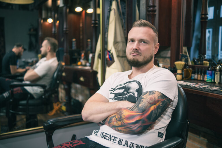 Klient relaksuje się w fotelu, podczas gdy doświadczony barber Gorzów Wielkopolski precyzyjnie modeluje jego brodę w Picasso Barber Shop.